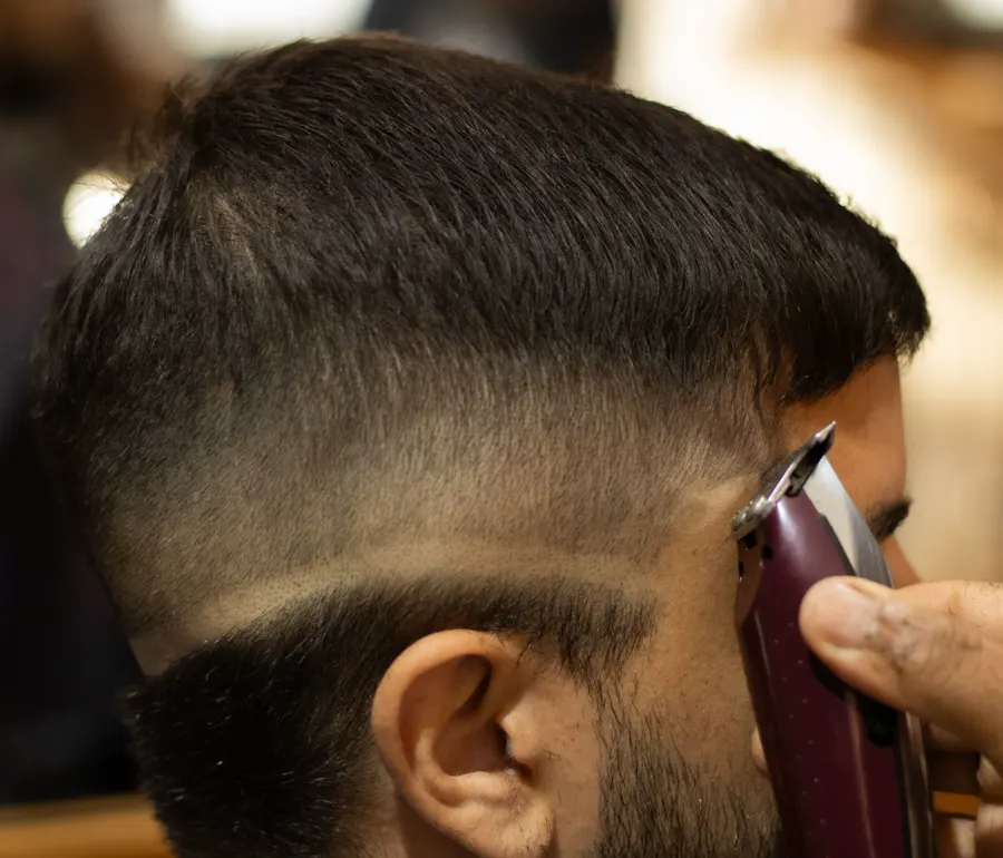 Barbero marcando un degradado con la máquina