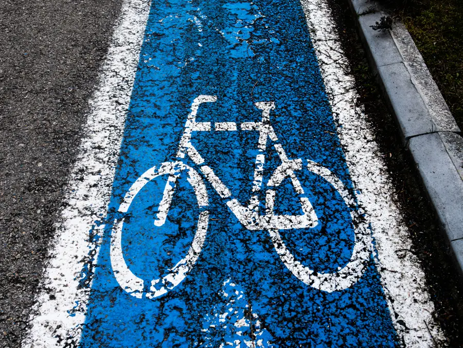 Ciclovía pintada de azul con el símbolo de bicicleta