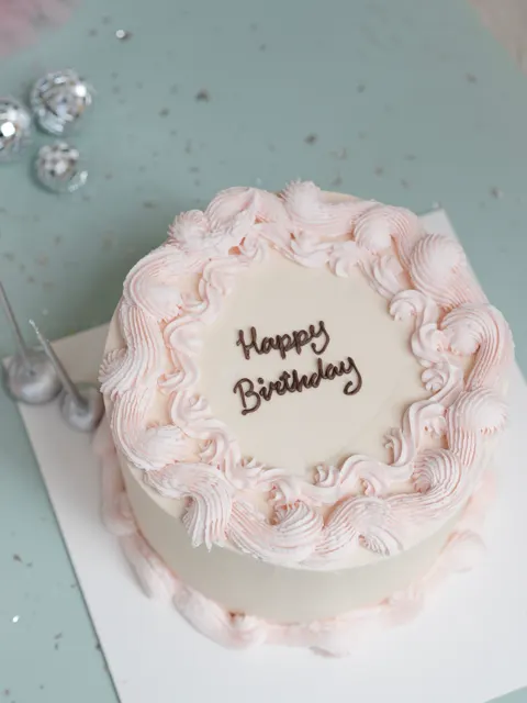 Torta de cumpleaños con rosetas rosadas vista desde arriba
