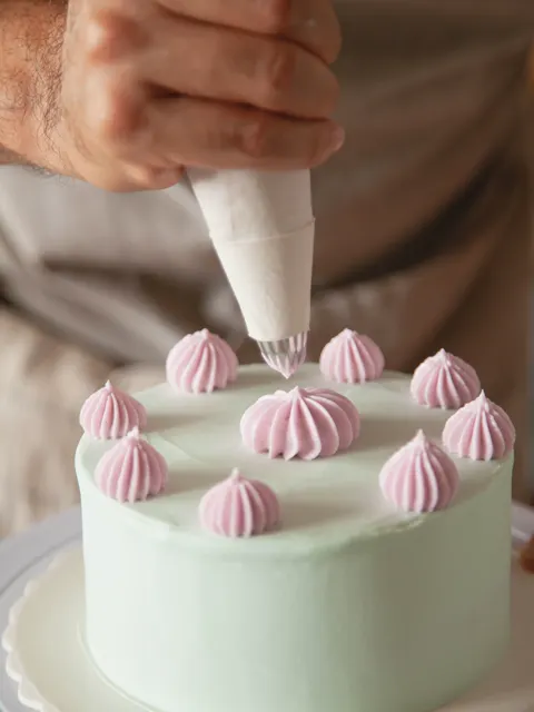 Decorando una torta celeste con manga pastelera