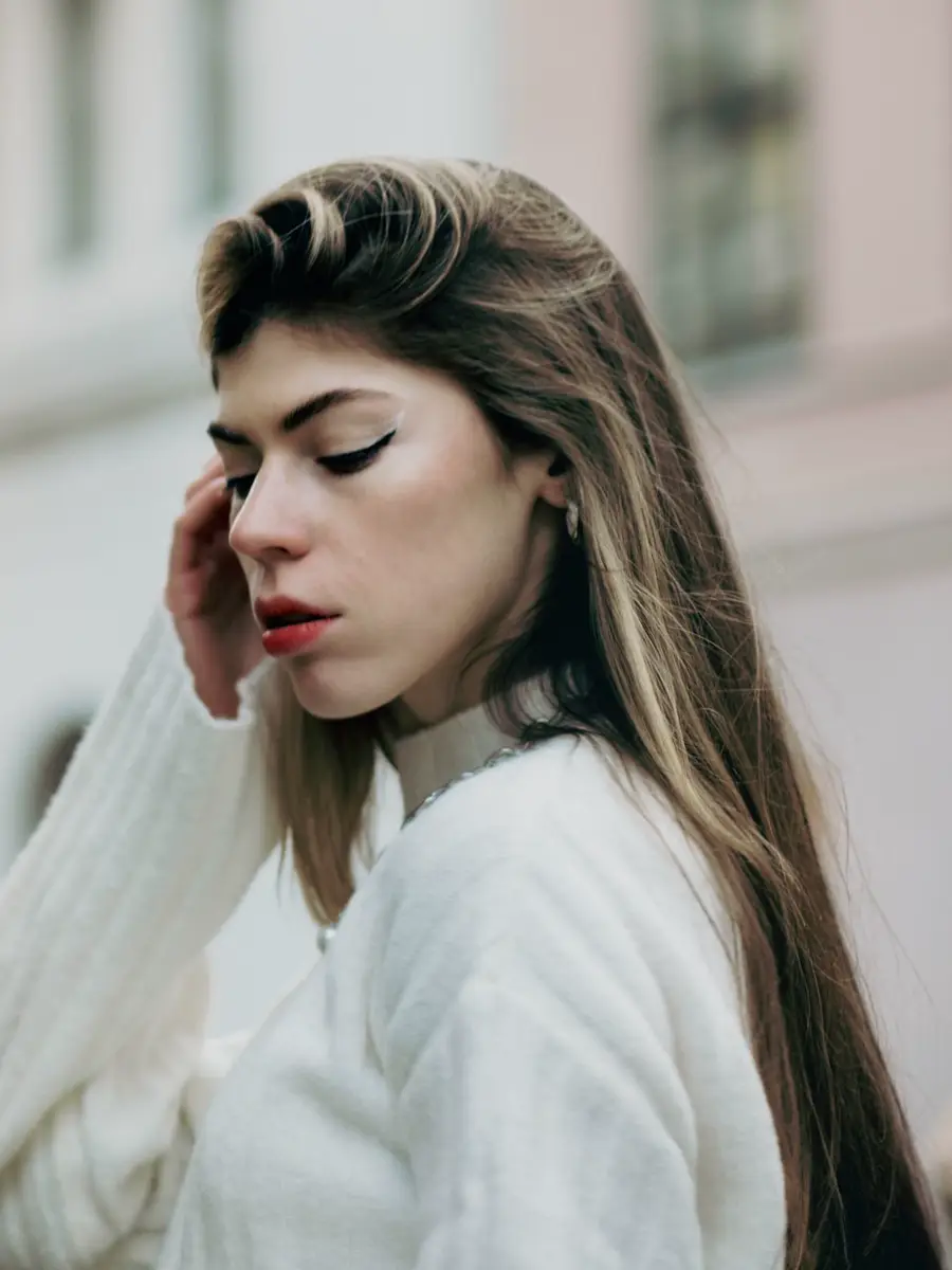 Mujer con chompa blanca de punto en una calle